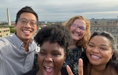 Ashley and a group of her friends and colleagues smiling, with a backdrop overlooking Washington, DC.