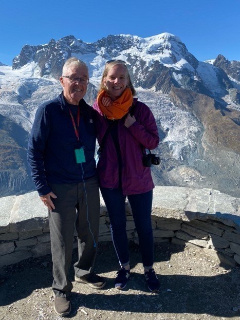 A person and person standing on a rock.