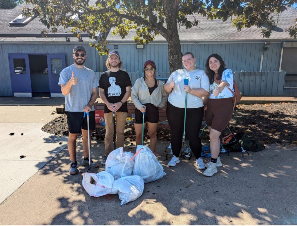 5 FMP employees outside cleaning up trash.